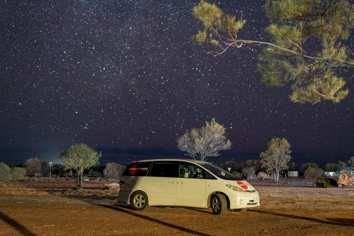 Campervan parked on campsite on a starry night in Australia